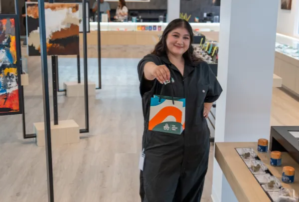 Laguna Woods Sales associate holding out a shopping bag